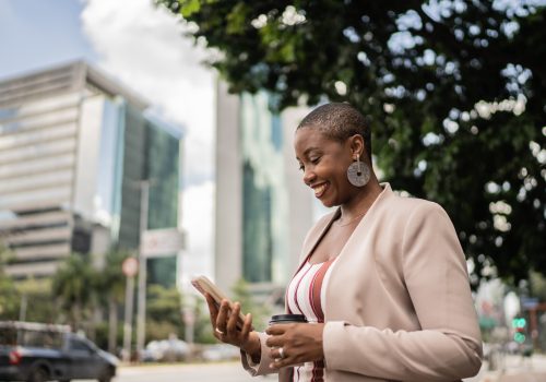 Business woman using smartphone waiting for taxi ride